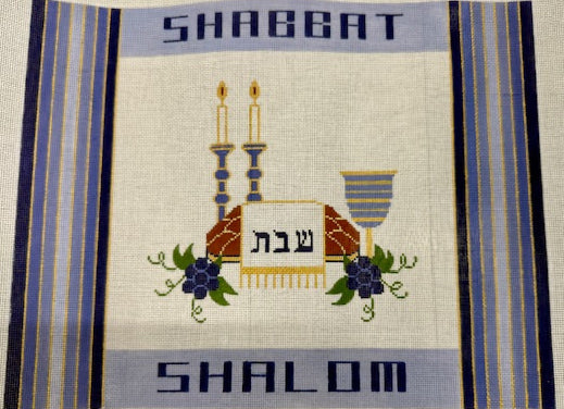 Blue and White Challah Cover with candles and challah.