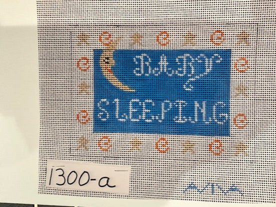  A needlecraft kit depicting a sleeping moon with stars surrounding it. Predominantly blue and white.